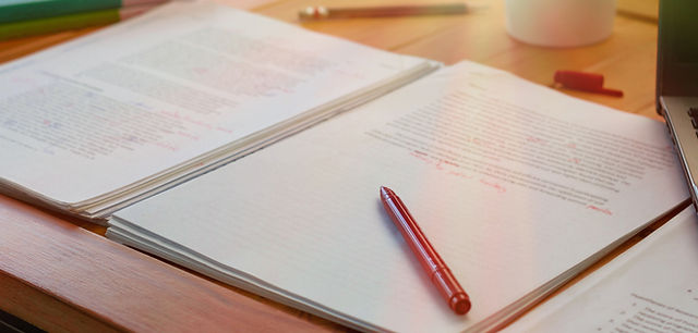 書類の山にペンを載せる